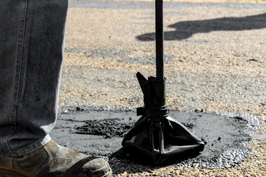Close-up of road repair work in South Africa, featuring asphalt patching tools.